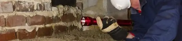 Pest control technician inspecting a crawl space for ant activity and entry points in Arlington, TX